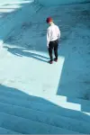 Man inspecting a drained inground pool.