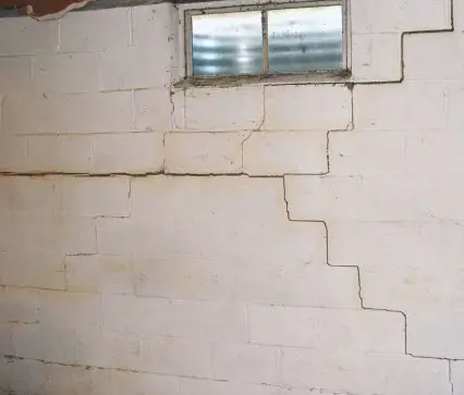 Cracks in a concrete block basement wall can be caused by rain water soaking into the ground and creating pressure on the wall.