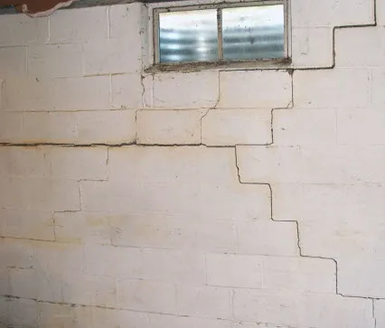 Cracks in a concrete block basement wall can be caused by rain water soaking into the ground and creating pressure on the wall.